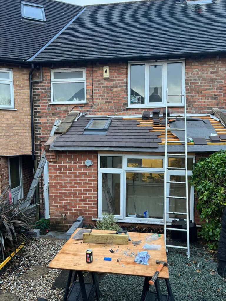 This is a photo of a roof extension that is having new roof tiles installed. This is a photo taken from the roof ridge looking down a tiled pitched roof on to a flat roof. Works carried out by Bexleyheath Roofing Repairs