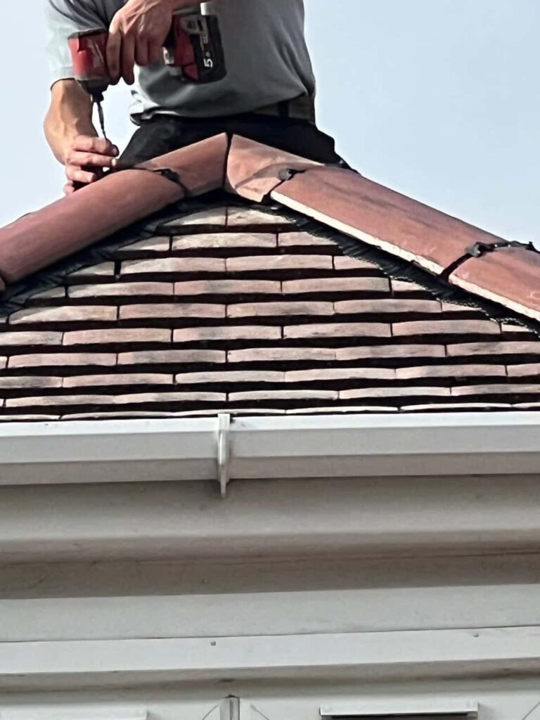 This is a photo of one of the operatives of Bexleyheath Roofing Repairs installing new ridge tiles