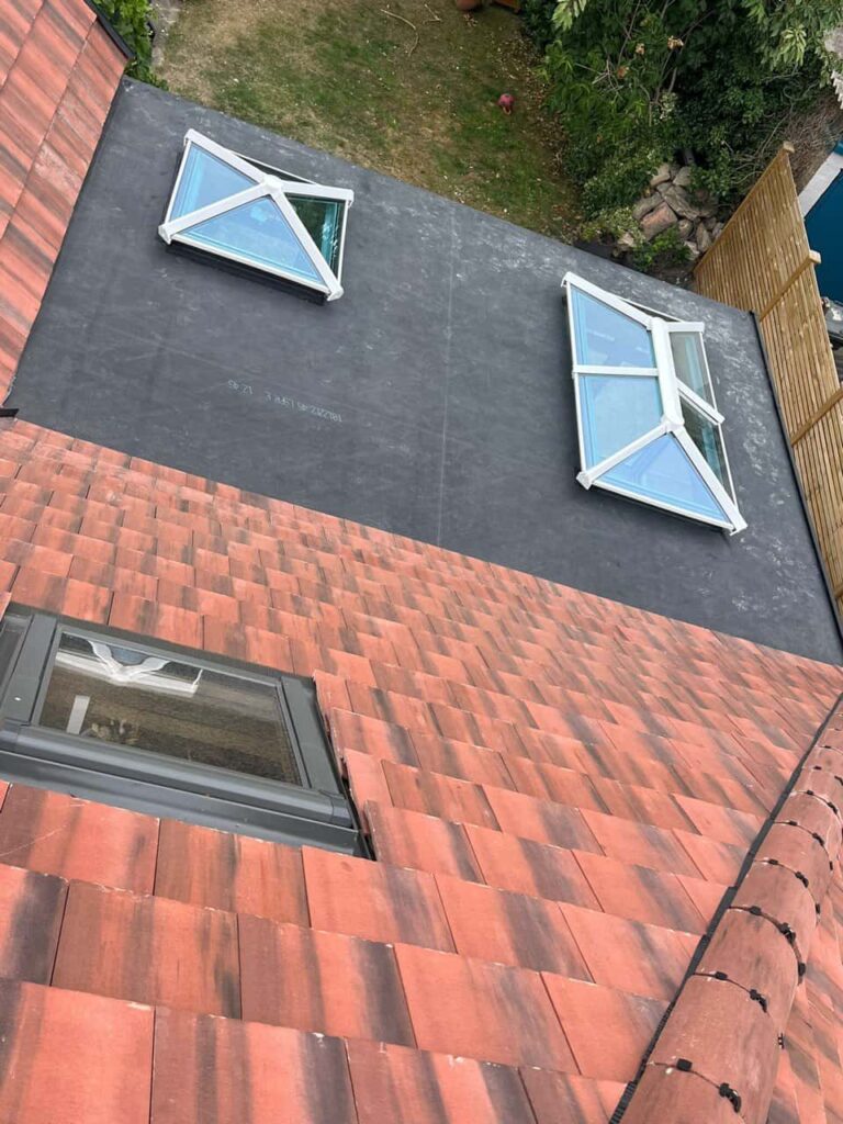 This is a photo taken from the roof ridge looking down a tiled pitched roof on to a flat roof. Works carried out by Bexleyheath Roofing Repairs